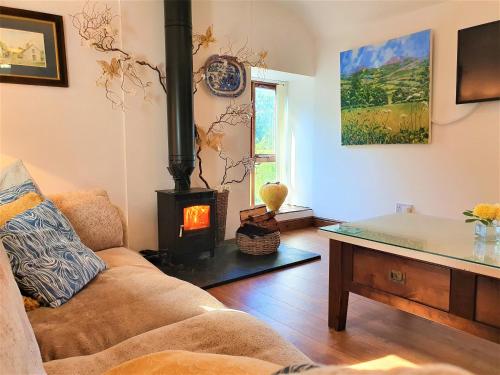 a living room with a couch and a wood stove at The Coach House in Ruthin