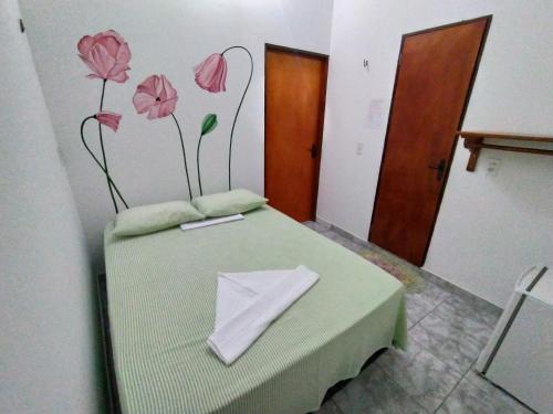 a room with a bed with pink flowers on the wall at Suíte central Pousada in Jijoca de Jericoacoara