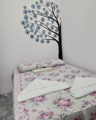 a bedroom with a bed with a tree on the wall at Suíte central Pousada in Jijoca de Jericoacoara
