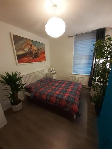 um quarto com uma cama com um cobertor xadrez em BIG BEN'S SHADE em Londres