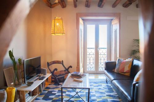 een woonkamer met een bank en een tafel bij FLH Duque Mezzanine with View in Lissabon