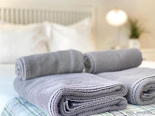 a pile of towels sitting on top of a bed at Encantador apartamento junto al Mediterraneo WIFI in Puerto de Sagunto