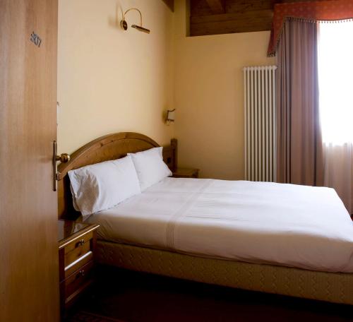 a bedroom with a white bed with a window at Grand Hotel Paradiso in Passo del Tonale