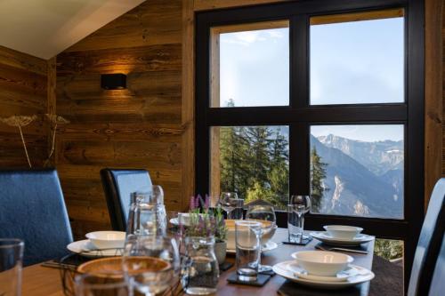 a dining room with a table and a window at Paradise Awaits in the Mountains of La Tzoumaz in La Tzoumaz