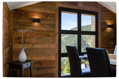 a dining room with a window and a table with chairs at Paradise Awaits in the Mountains of La Tzoumaz in La Tzoumaz