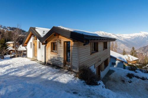 a house in the snow with mountains in the background at Paradise Awaits in the Mountains of La Tzoumaz in La Tzoumaz