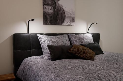 a bedroom with a black bed with two lamps on it at Hof Welzinge in Ritthem