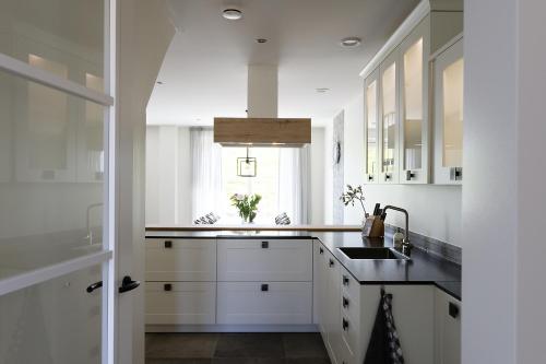 a white kitchen with a sink and a window at Hof Welzinge in Ritthem