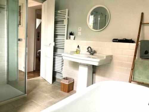 une salle de bain avec un lavabo et un miroir dans l'établissement Villa vue mer avec acces direct a la plage, à Varengeville-sur-Mer