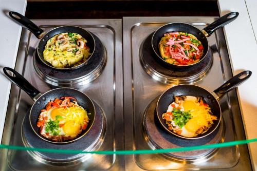 two pans of food on a stove top at Borodino Hotel in Moscow