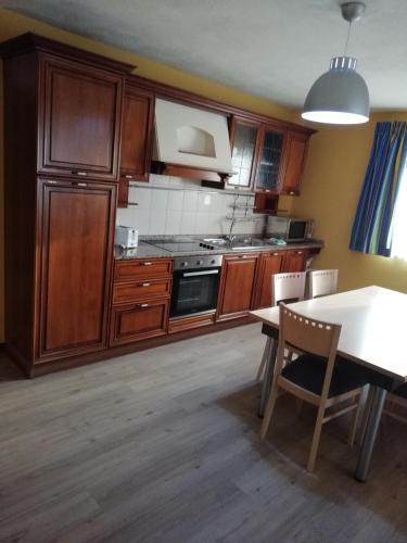 a kitchen with wooden cabinets and a table with a dining room at Sunseeker Holiday Complex in St Paul's Bay