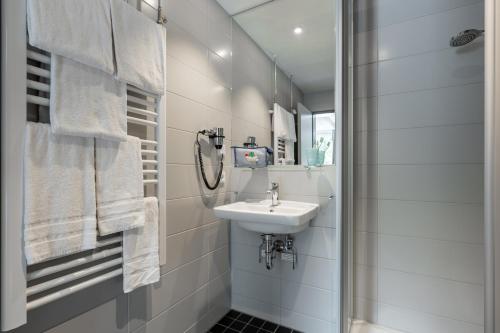 a white bathroom with a sink and a mirror at Serways Hotel Rhynern-Süd in Hamm