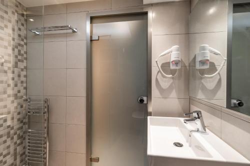 y baño con lavabo y espejo. en Xenophon Hotel, en Atenas