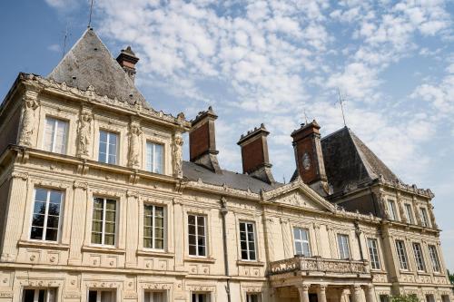 un antiguo edificio con una torre de reloj encima en Chateau L' Escale, en Saint-Herblon