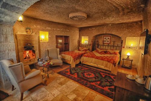 a large bedroom with a bed and a fireplace at Traveller's Cave Hotel in Goreme