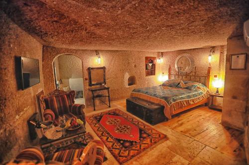 a bedroom with a bed and a chair in a room at Traveller's Cave Hotel in Goreme