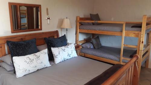 Zimmer mit 2 Etagenbetten und einem Spiegel in der Unterkunft Natures Rest Lapa in Oudtshoorn