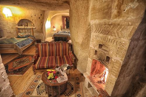 a living room with a large stone fireplace at Traveller's Cave Hotel in Goreme