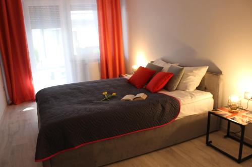 a bedroom with a bed with two slippers on it at Apartament Orange Sun nr°7 in Pobierowo