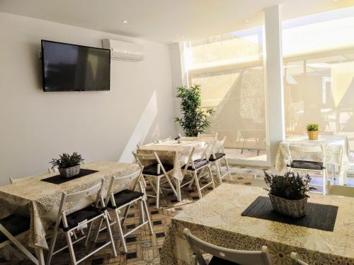 a dining room with tables and chairs and a flat screen tv at Lo Trabucador Casa nueva en el corazón del Delta in Poblenou del Delta