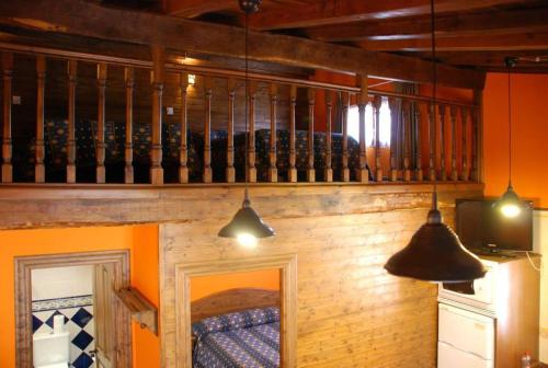 a room with a wooden wall and two pendant lights at Apartamentos Rurales Les Martes in Felechosa