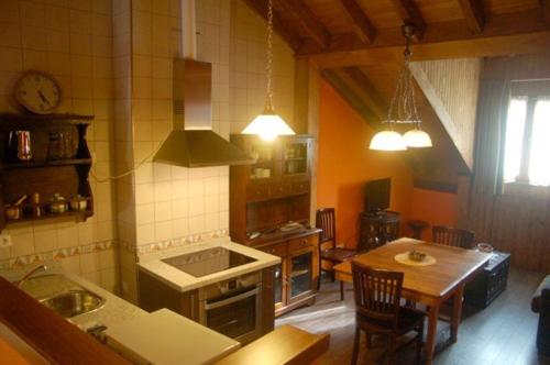 a kitchen with a table and a stove top oven at Apartamentos Rurales Les Martes in Felechosa