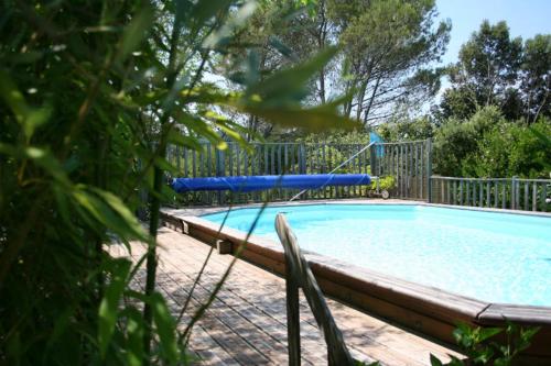 a swimming pool with a blue tube in a yard at Gite des oliviers in La Roque-sur-Cèze