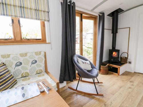 a living room with a couch and a chair at Betws View, Shepherd Hut in Betws-y-coed