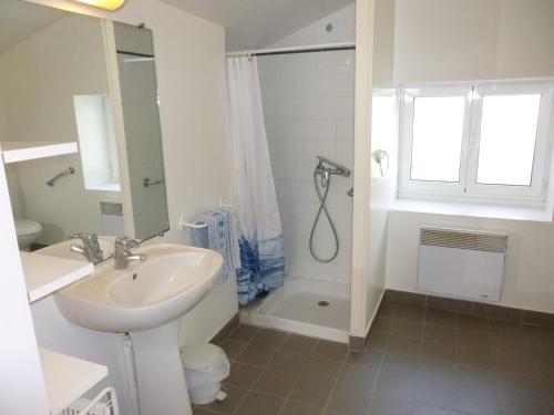 une salle de bain blanche avec un lavabo et une douche dans l'établissement Gîtes de L'Eguille, à LʼÉguille