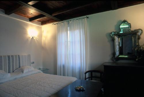 a bedroom with a bed and a mirror and a table at Locanda Tramonti in La Spezia