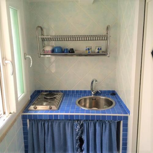 a bathroom with a sink and a blue tiled counter at Scala Blu - Immobilevante in Ponza
