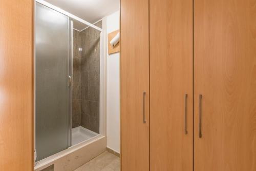 een badkamer met houten kasten en een douche bij Villa Loza - Resort Moja stina in Seoca