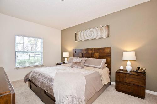a bedroom with a bed and two lamps and a window at Great And Practical Townhouse In Gated Community, Sleeps 6 10 Min To Disney! in Orlando