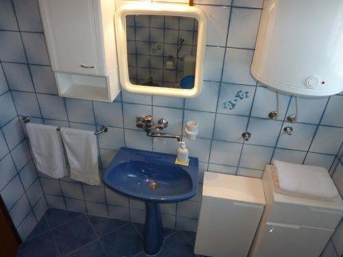 W łazience znajduje się niebieska umywalka i lustro. w obiekcie Three bedroom apartment & studio - Apartments Ždrijac w Nin