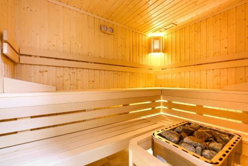 a wooden sauna with a tray of rocks in it at Olimpijska 2 - City Apartments in Mielno
