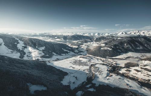 an aerial view of a snow covered mountain with a river at Hotel Fameli in Valdaora