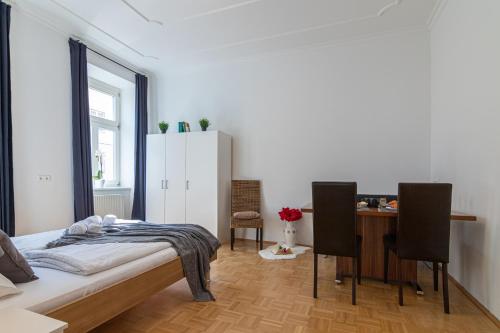 Schlafzimmer mit einem Bett, einem Tisch und Stühlen in der Unterkunft Yeshello Elegant Apartment near Central Vienna in Wien