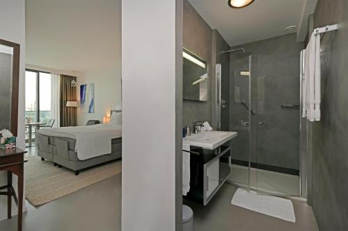 une salle de bain avec un lit, une douche et un lavabo dans l'établissement Black Jack Suites, à Amsterdam