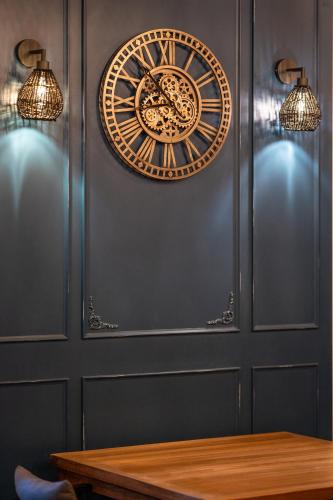 a gold clock on the wall next to a table at Majestic Hotel in Oludeniz