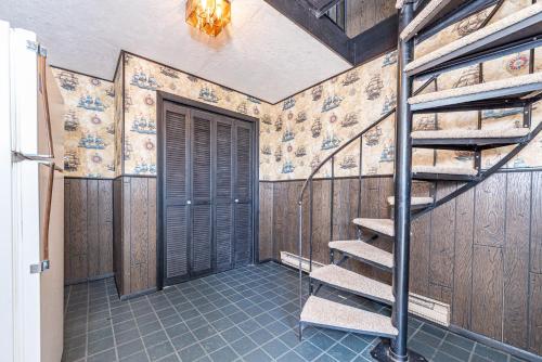 a staircase in a room with wooden walls and a door at The Green House in Kitty Hawk