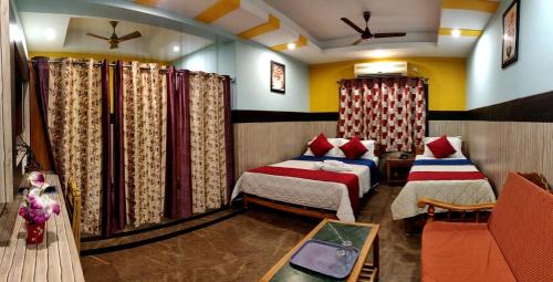 1 dormitorio con 2 camas y 1 sofá en una habitación en Hotel nala residency, en Tiruvannāmalai