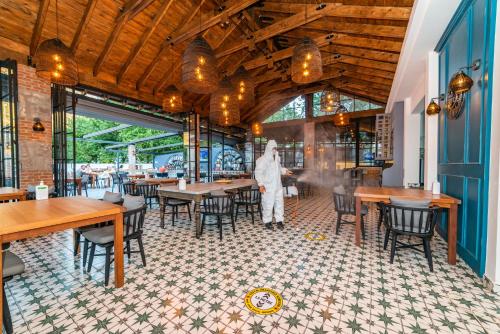 a person standing in a dining room with tables and chairs at Majestic Hotel in Oludeniz