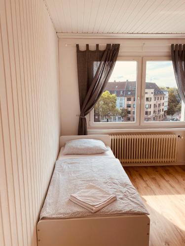 a small bedroom with a bed and a window at TM Aparts in Dortmund
