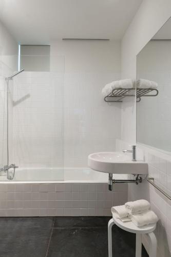 a white bathroom with a sink and a tub at Quinta da Caída in Arcas