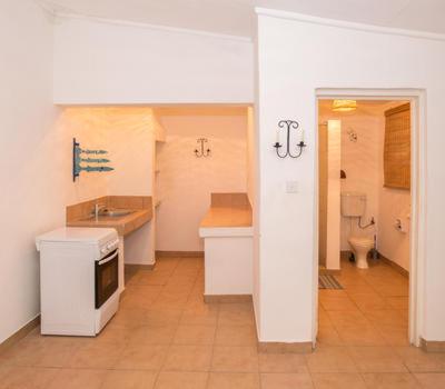 uma cozinha com um lavatório e um WC num quarto em Sunbird Chintheche em Nkhata Bay