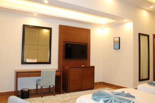 a bedroom with a bed and a desk and a television at Royal Jewel Al Raml Hotel in Alexandria