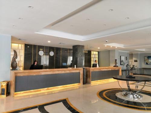 a lobby with a table and people in a building at Royal Jewel Al Raml Hotel in Alexandria