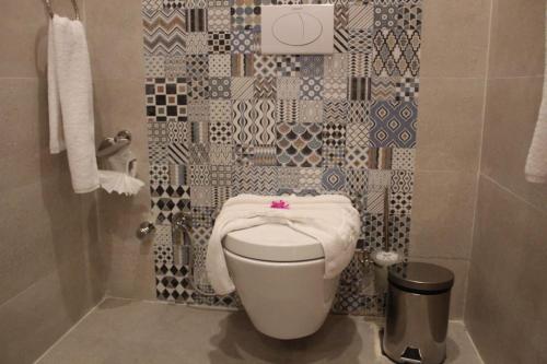 a bathroom with a toilet with a towel on it at Royal Jewel Al Raml Hotel in Alexandria