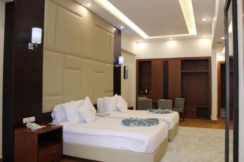 a hotel room with two beds and a table at Royal Jewel Al Raml Hotel in Alexandria