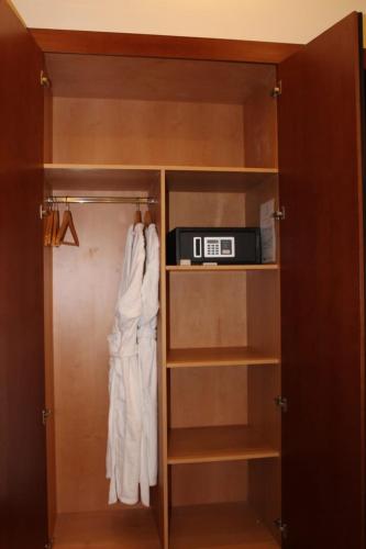 a closet with a robe and a clock in it at Royal Jewel Al Raml Hotel in Alexandria